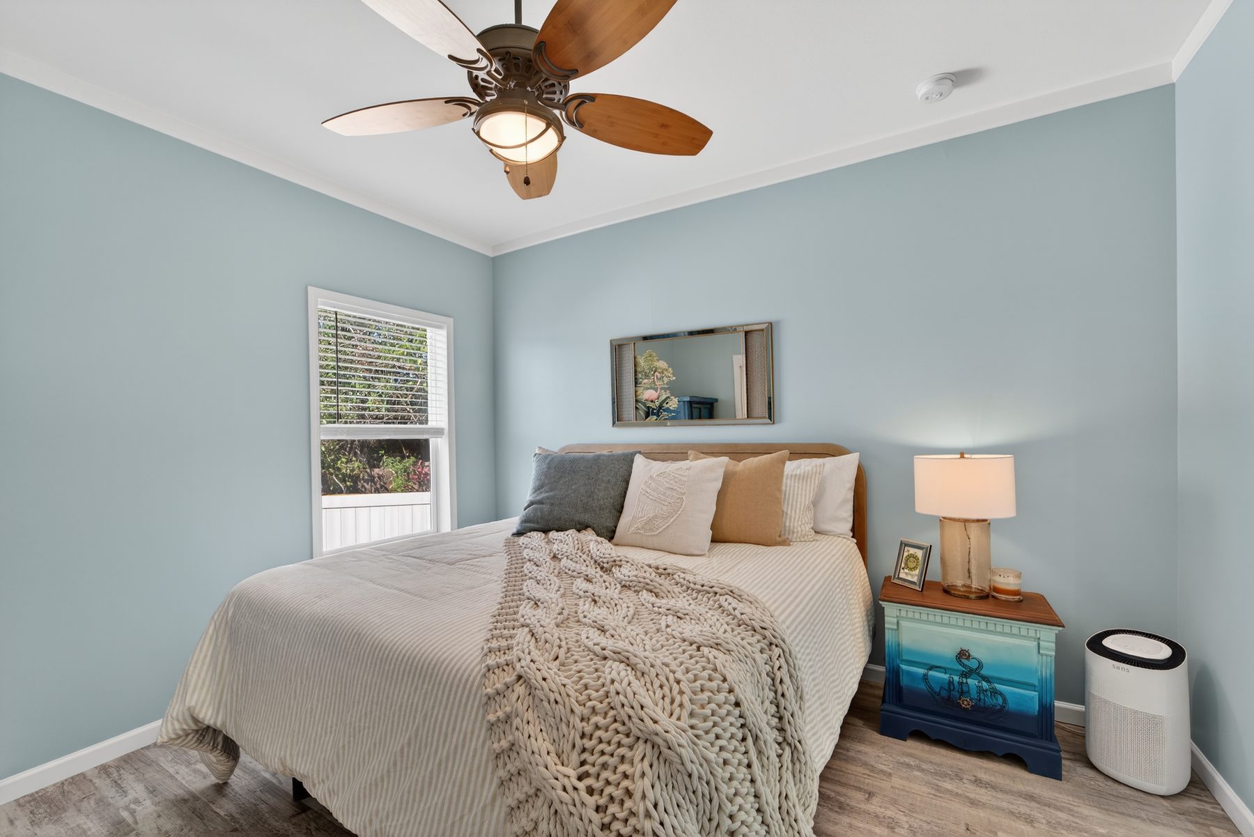 Bedroom in soft blue with hand-painted nightstand