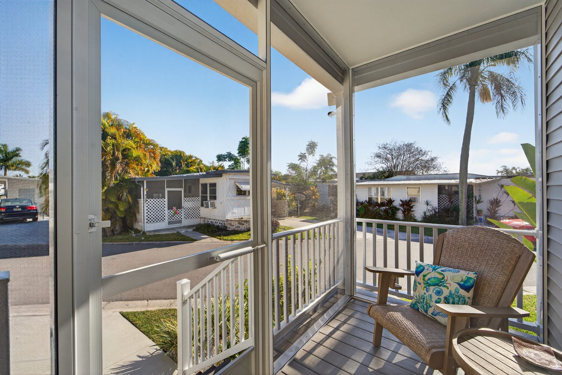 Screened porch with two chairs and street view